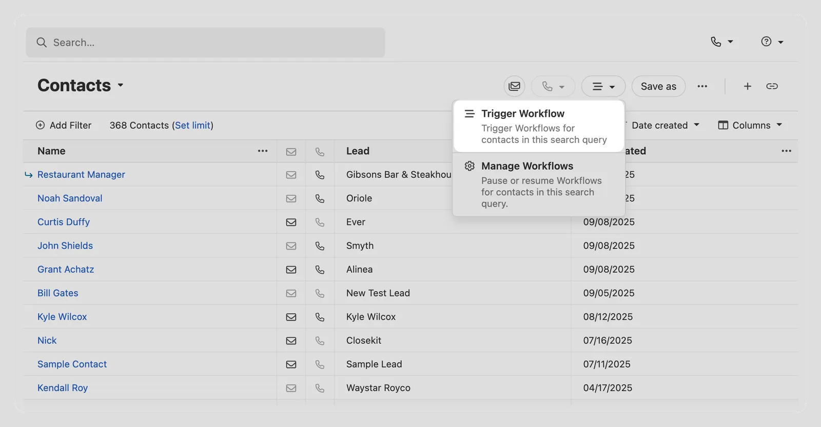 Contacts list view with a dropdown showing Trigger Workflow and Manage Workflows options.